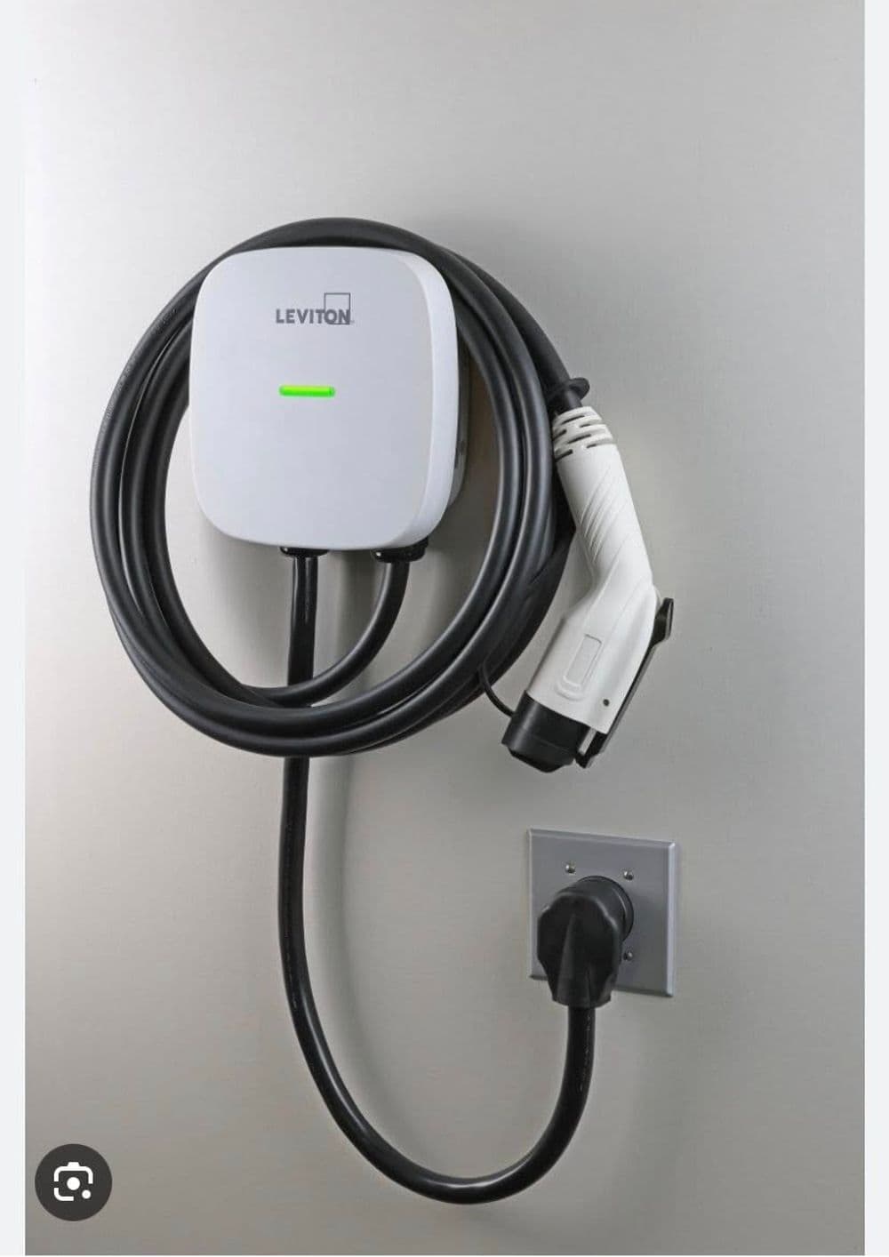 Leviton electric vehicle charger mounted on wall with charging cable neatly coiled.
