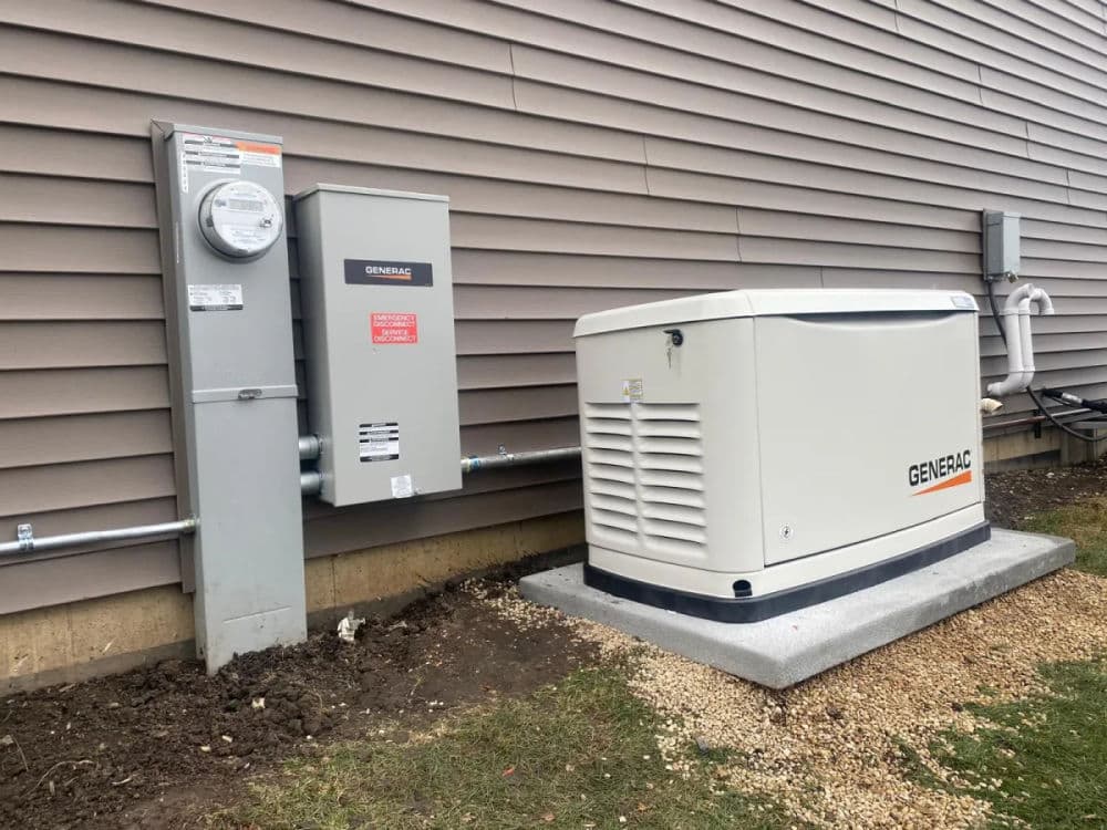 Generac home generator installation beside the utility meter on a residential exterior wall.