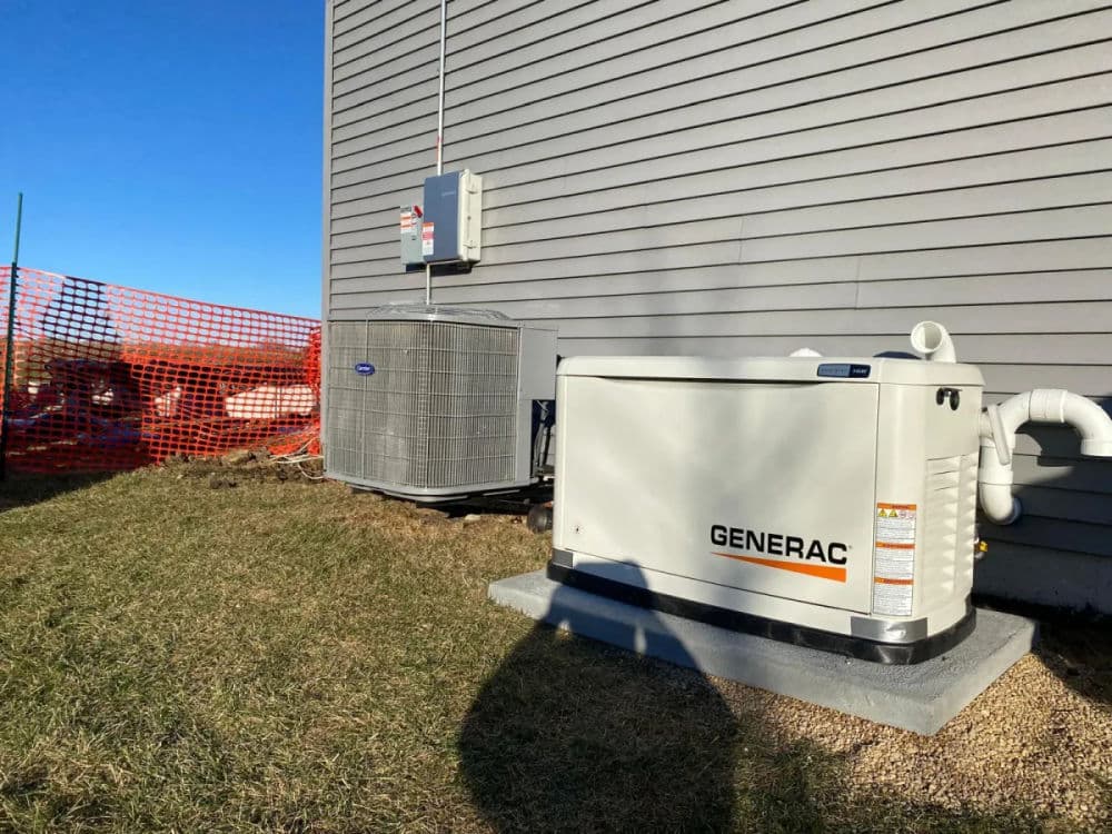 Generac generator installed beside an air conditioning unit on a property.